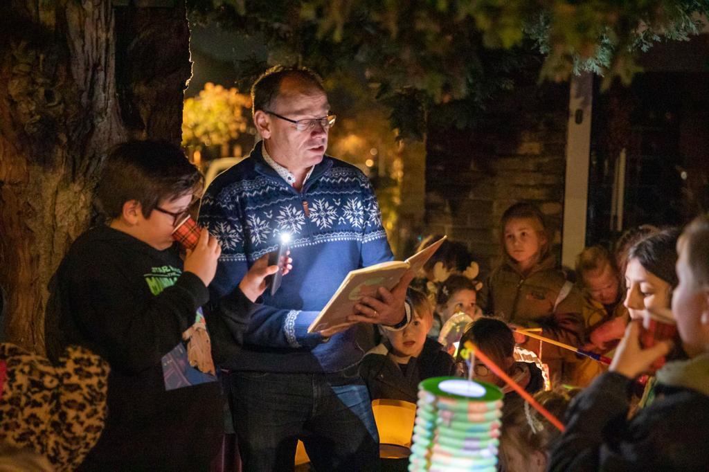 Voorleesmoment onder een boom met lampionnen